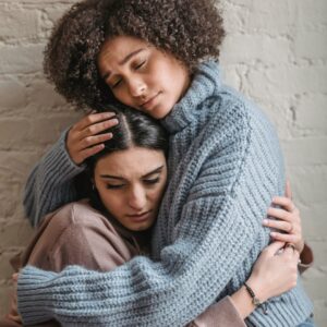 Individual hugging a grieving friend